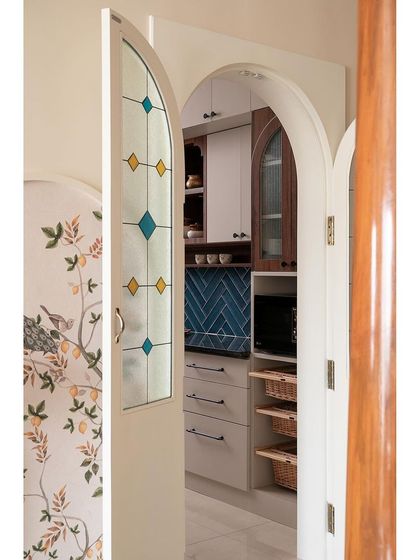 To provide privacy for the open kitchen, I designed this beautiful arched door with stained glass panels. It adds to the home's traditional aesthetic while allowing light to pass through.