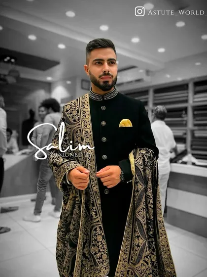 A client in a black Indo-Western jacket paired with a beautifully embroidered pashmina shawl. The combination of the simple jacket and detailed shawl creates a balanced and elegant look.