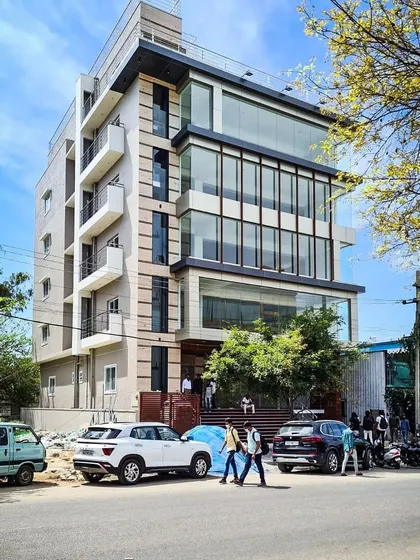 The completed commercial building for Mr. Shivaram in HSR Layout, a bustling commercial hub in Bangalore. This structure features a prominent multi-story glass facade, a signature element of our modern architectural style, designed to maximize natural light and create a strong street presence.