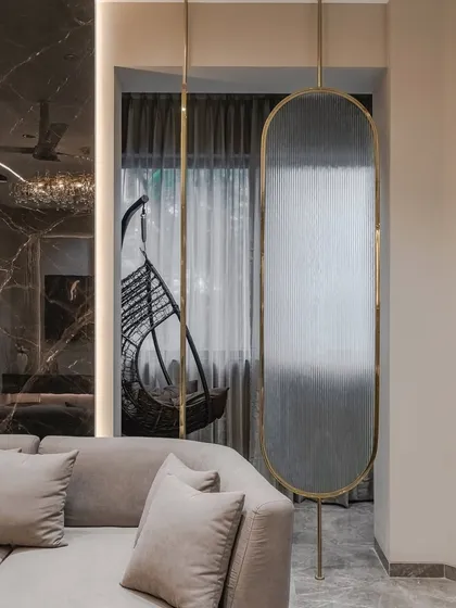 We use partitions to define spaces without closing them off. This movable glass partition, framed in elegant brass, adds a sophisticated style while allowing for flexible layouts. It enhances the sense of openness and light, bringing a modern, airy feel to the home.