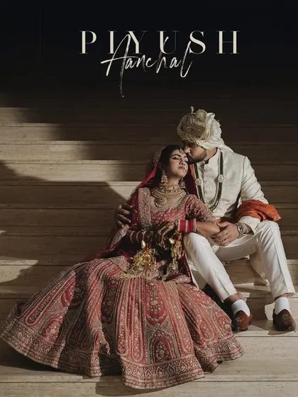 A romantic portrait of the couple seated on stairs, the groom kissing the bride's forehead. A timeless and intimate wedding shot.