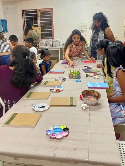 A mixed media journal cover workshop in progress. This is a fantastic activity for birthday parties, allowing kids to experiment with different materials.
