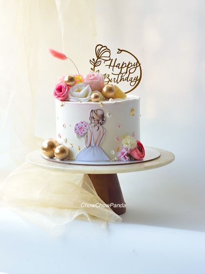 A beautiful and feminine cake design. This Chocolate Truffle cake features an edible print of a girl in a gown, surrounded by fresh flowers and gold accents.