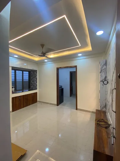 An empty living room with the false ceiling and lighting completed. The recessed cove lighting provides a soft, uniform glow, setting the stage for the furniture to come.