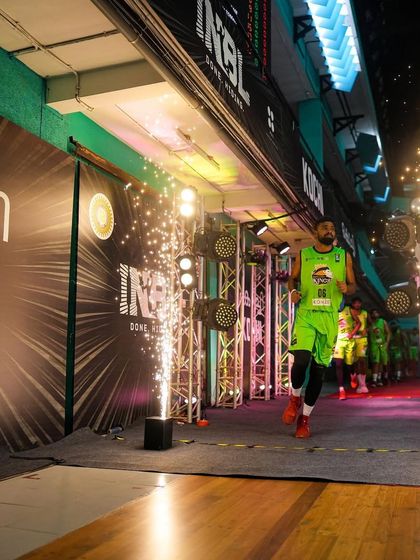 A player runs onto the court through a tunnel of lights and pyrotechnics at an INBL game in Kochi. We specialize in creating these spectacular player introductions.