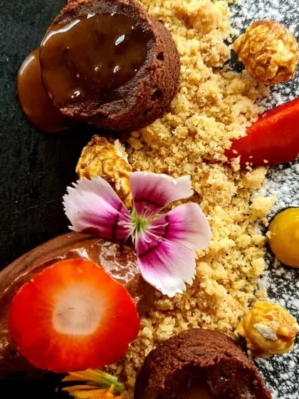 Our deconstructed chocolate and caramel dessert. It features chocolate lava cake, mousse, fresh strawberries, and caramel popcorn, a playful and indulgent end to a gastronomic sit-down dinner.