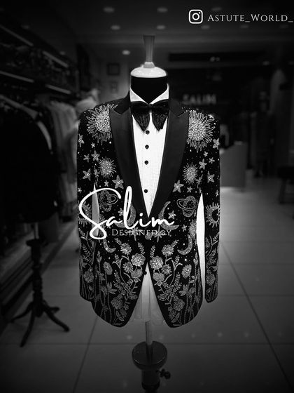 A black and white photo of the celestial-themed tuxedo on a mannequin. Even without color, the incredible detail of the sun, moon, and stars embroidery is stunning.