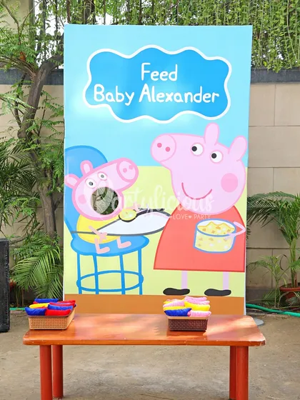 An interactive "Feed Baby Alexander" game board, adding a fun activity for the little guests at the Peppa Pig party.