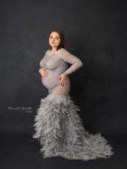 A unique and glamorous gown. The feathered skirt on this silver-grey dress adds incredible texture and a high-fashion element to this stunning portrait.