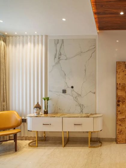 A beautiful console table against a statuario marble panel, with a unique burl wood veneer door, showcasing our use of exotic materials.