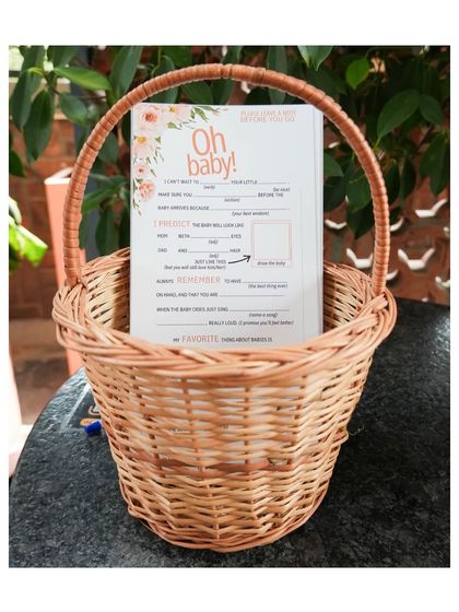 Thoughtful details include fun, interactive games. Here, "Oh Baby!" prediction and advice cards are ready for guests in a rustic wicker basket.