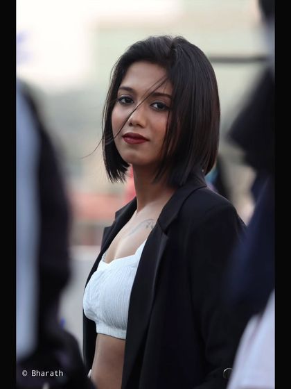 A close-up version of the creatively framed shot, bringing the focus to the subject's intense gaze and the wind in her hair.