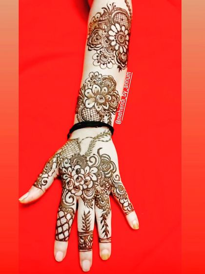 This design is a beautiful example of Arabic fusion, with bold flowers, leafy vines, and intricate patterns on the fingers, all tied together with a wristband.