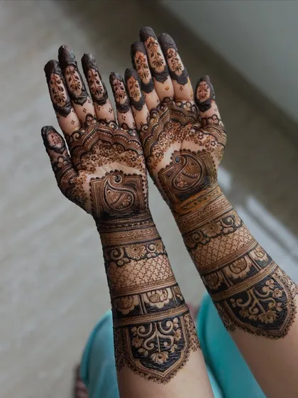 This design features the classic paisley motif, a symbol of life and eternity, woven into a dense pattern that extends up the arm.