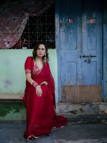 The contrast between the elegant red saree and the rustic blue door creates a visually compelling story. This is what I love about on-location editorial shoots in Mumbai.