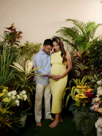 The father-to-be joins his partner in the indoor garden set, his hand gently on her bump. This shot captures their shared journey in a vibrant, naturalistic setting we created in the studio.