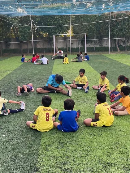 A coach leading a stretching session. Our coaches create an environment where young talents can thrive, both on and off the field.