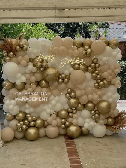 Our balloon walls are guaranteed to be the centerpiece of your party. This full-scale installation uses a soft, neutral palette of white, beige, and chrome gold for an elegant and modern birthday backdrop.