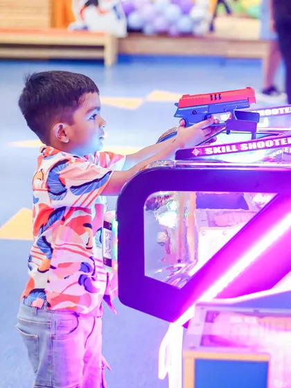 Another young player trying his luck at the "Skill Shooter" game. The glowing lights make it extra appealing.