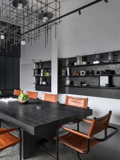 The main conference room features a large black table, leather chairs, and a custom grid-like light fixture, creating a powerful and sophisticated meeting space.