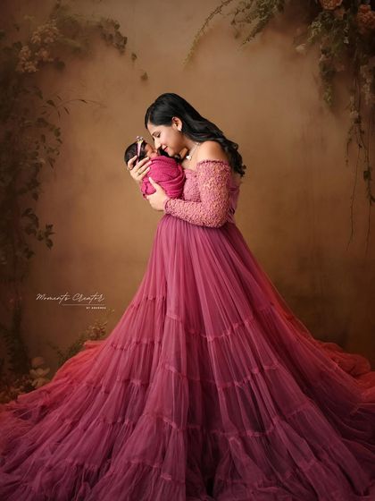 A mother's tender gaze at her 21-day-old newborn. The soft lighting and her flowing gown create a serene and painterly portrait that highlights the bond between them.