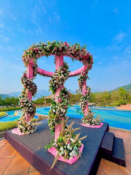 This angle showcases the full structure of the pink poolside mandap, a perfect blend of modern design and natural beauty.