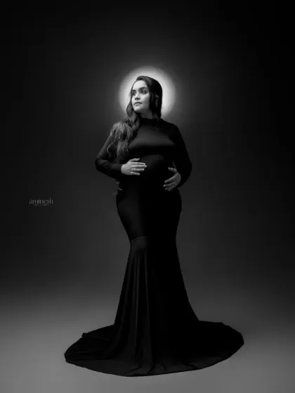 Sometimes, a simple portrait is the most powerful. Using dramatic studio lighting and a classic black and white finish, I focus entirely on the mother's strength and beauty during her pregnancy.