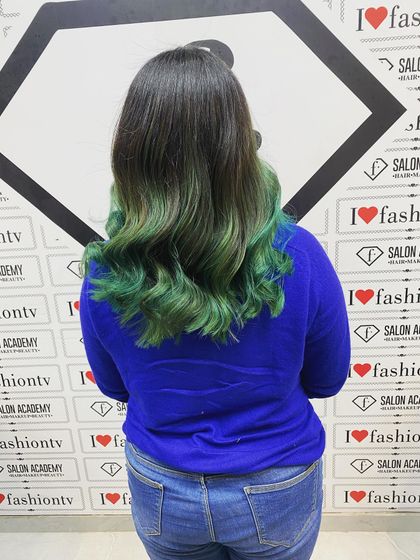 The final result of the green ombre hair coloring, beautifully styled into soft waves to showcase the seamless color blend achieved by our student.