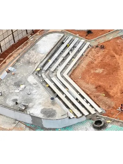 A close-up of the amphitheater seating under construction, showing the concrete formwork and terraced design.