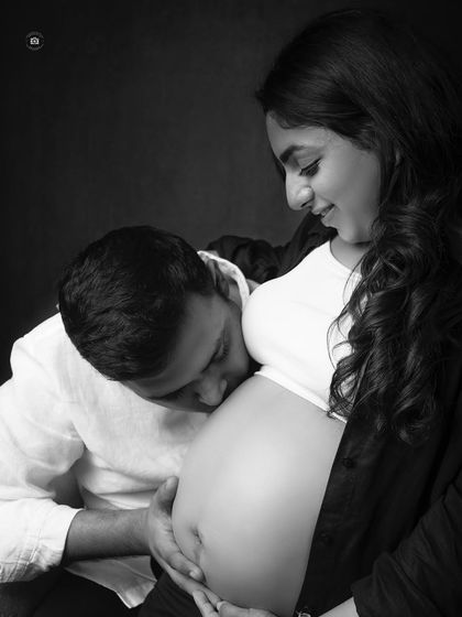A tender black and white close-up of a partner kissing the baby bump. This intimate shot beautifully captures the love for the coming baby.