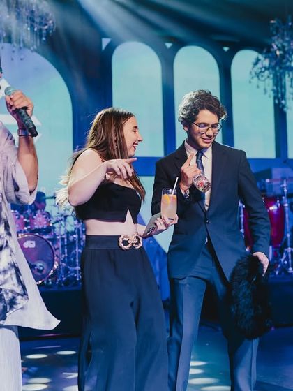 An unscripted, fun moment on stage with the performers, capturing the spontaneous joy that makes a Sangeet memorable.