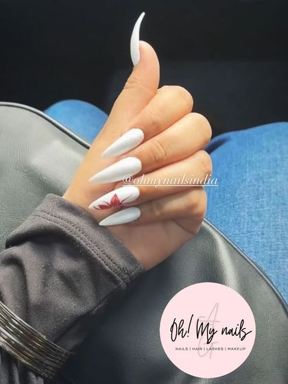 White for the win. This clean and striking look features long, sharp stiletto nails in a solid, opaque white, with a single accent nail featuring a red maple leaf.