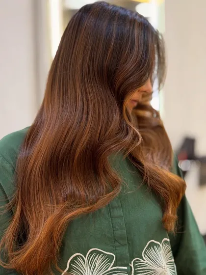 A close up look at the beautiful dimension in this cinnamon brown hair color. The way the light catches the different tones is what makes a professional color service stand out.