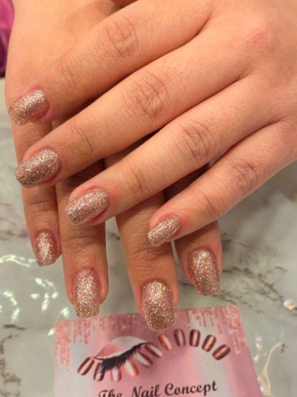 A full set of dazzling rose gold glitter nails. These short, square-shaped nails are perfect for when you want a simple design that still makes a big impact.