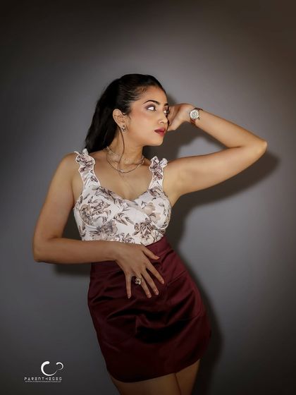 A classic studio pose that exudes elegance. The lighting is soft yet directional, highlighting the details of her outfit and the graceful curve of her posture.