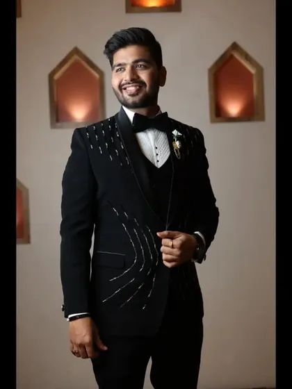 The groom looking dapper and happy. The three-piece suit is complemented by a sharp hairstyle and defined makeup.
