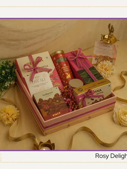 The 'Rosy Delight' hamper. A pretty pink-themed tray filled with assorted chocolates, brittle, and a diya, making it a sweet and charming gift for the festival of lights.