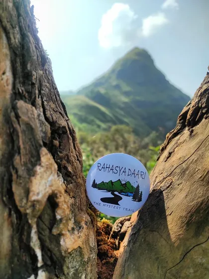 A creative shot of my badge nestled in a tree, with the Ettina Bhuja peak in the background. It represents my commitment to finding unique perspectives on popular trails.