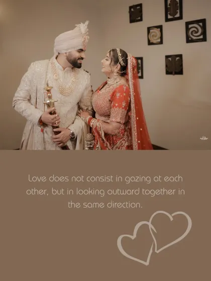 A classic couple portrait after the wedding ceremony. The bride in her red lehenga and the groom in his ivory sherwani share a look of love and admiration.