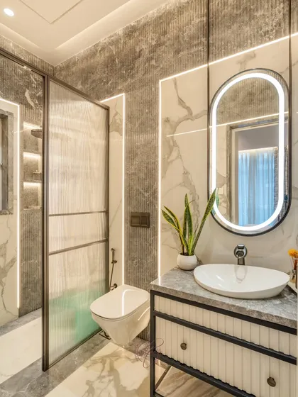 A full view of the bathroom, showing the clear separation between the wet and dry areas using a fluted glass partition. The design is both functional and aesthetically pleasing.