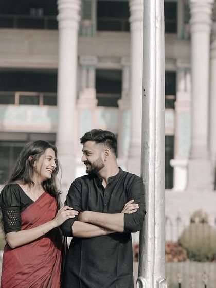 A classic pre-wedding pose by a lamppost, with the couple in traditional wear and the grand Vidhana Soudha behind them.