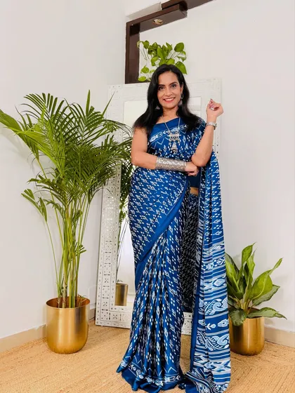 An indigo blue ikat-style print on a soft satin fabric. This saree gives a traditional yet modern vibe, perfect for a creative workplace.