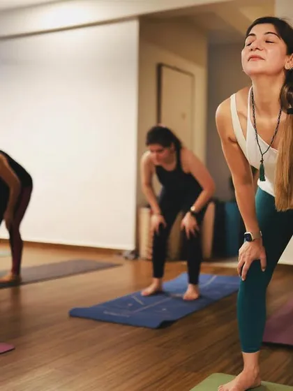 A moment of release and breath. This student is taking a moment between poses, a reminder that the pauses in yoga are just as important as the postures themselves.