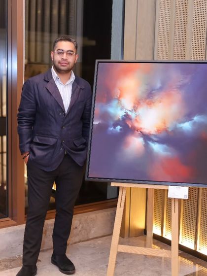 The founder of Rubix Collective, who collaborated with us on 'Mystic Mirage', standing next to one of Simon Kenny's cosmic paintings.