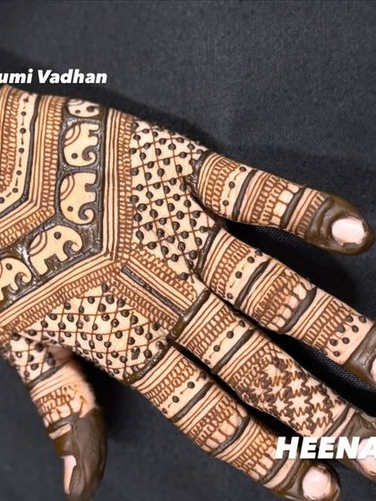 A close-up of a back-hand design featuring delicate elephant motifs and fine line work.