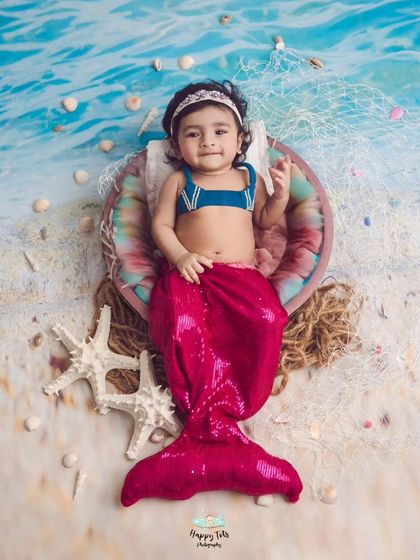 A beautiful little mermaid from under the sea. We use a beachy backdrop, fishing nets, and a sparkly mermaid tail to create this magical ocean scene.