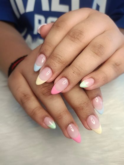 Can't decide on one color? Try them all! These pastel rainbow French tips on almond-shaped extensions are a fun and playful way to add a pop of color to your look.