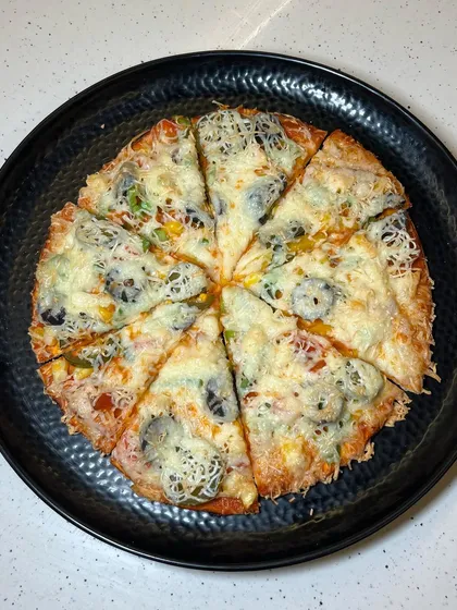 A top-down view of my All Veg Pizza, showcasing the colourful toppings and generous amount of cheese.