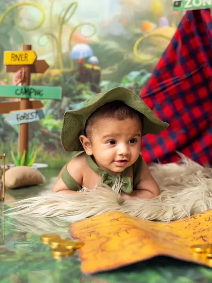 This little explorer is studying his treasure map. Our camping theme is filled with fun details like a felt campfire, an hourglass, and golden coins.