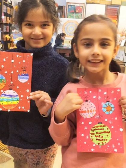 The Christmas spirit is alive in my toddler group! These two are showing off the festive Christmas cards they made using fingerprinting and collage techniques.